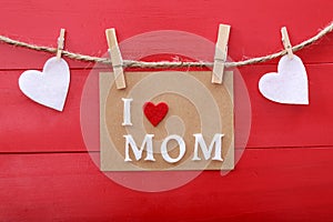 Mothers day message with clothespins over red wooden board