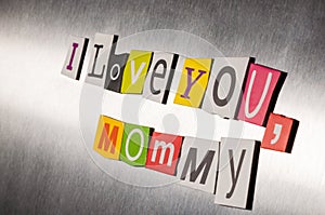 Mothers day message of color magazine letter clippings on metal background. I love you mom or mommy. Selective focus