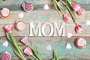 Mothers day message with tulips and cupcakes on wooden table