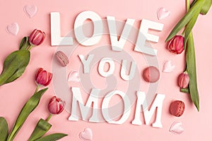 Mothers day message with tulips and macarons on pink background
