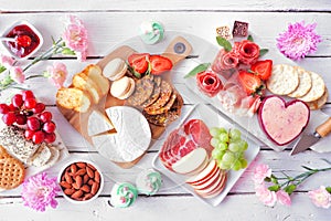 Mothers Day theme charcuterie table scene against a white wood background