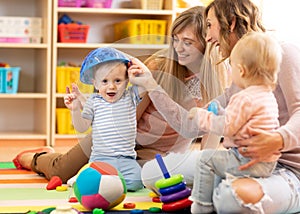 Mothers with kids play in playroom