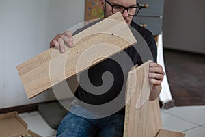 Motion blur Bearded guy collects furniture in a new apartment. close up