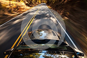 Motion blur of car driving down a road during Fall