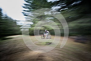 Motion blur. Cyclist man riding electric mountain bike outdoors.