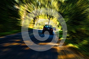 Motion blur - fast moving car on a winding forest road - fascinating mysterious beautiful abstract view