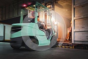 Motion Blur of Forklift Driver Loading Package Boxes into Shipping Container. Trailer Truck Parked Loading at Dock Warehouse.