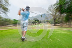 Motion blur golfer swinging driver