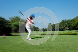 Motion blur golfer swinging driver club