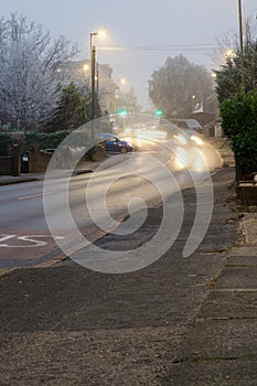 Motion blur lights on cars queuing down a hill on a frosty winter evening
