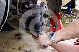 Motion blur of mechanic working on car wheel hub