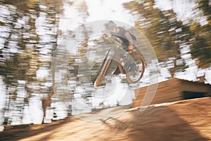 Motion blur, mountain bike and cycling, man with speed for extreme sports and training in fast adventure. Professional