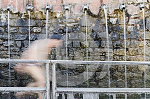 Motion blur of pilgrim running under the 108 holy taps in Muktinath temple in winter  Muktinath  Annapurna Circuit  Nepal