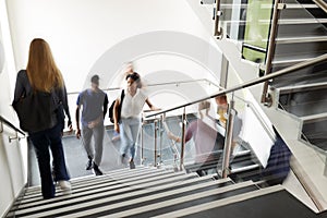 Motion Blur Shot Of High School Students Walking On Stairs Between Lessons In Busy College Building