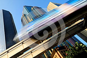 Motion blur of a skytrain speeding through a modern business district