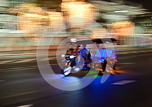 Motion blur of traditional tuk-tuk at night from Bangkok