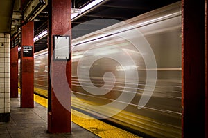 Motion blur of a train moving fast by a train station