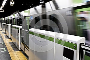 Motion blur of transportation subway train moving out from station