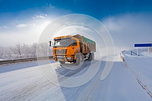 Motion blur of a truck on winter road on frosty day