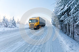 Motion blur of a truck on winter road on frosty sunny day