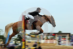 Motion blur unidentified equestrian rider show jump horse trying to overcome hurdles at Malaysia sport, Sukma in Pahang