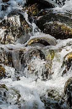 Motion blur water over mossy rocks.