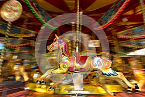 Motion blurr of vintage horse of amusement ride on merry-go-round carousel