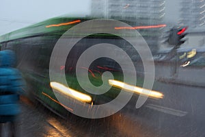 Motion blurred bus at dusk in inclement weather