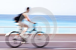 Motion blurred cyclist going fast on a city bike lane