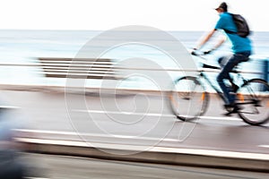 Motion blurred cyclist going fast on a city bike lane