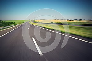 Motion blurred empty highway with green meadow on horizon