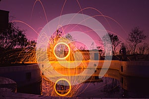 Motion blurred man are hurling Steel wool and sky violet color.