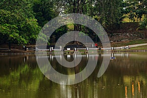 Motion blurred of people are running in urban park with water reflection