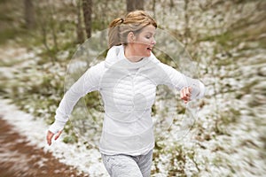Motion blurred photo of woman running outdoors in winter