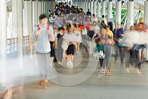 Motion blurred picture from many people walking in footbridge