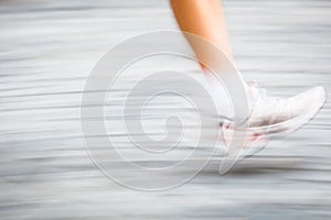 Motion blurred runner's feet in a city environment