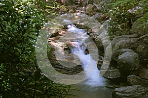 Motion blurred water cascading down Skinny Dip Waterfall in North Carolina