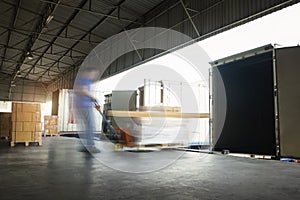 Motion Blurred of Workers Unloading Cargo Boxes Pallet into Container Trucks. Distribution Shipping Warehouse. Delivery Trucks.