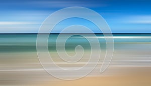 A motion blurry image of a beach with a blue sky in the background.