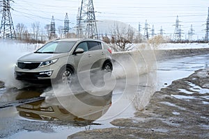 Motion car, big puddle of water spray from the wheels.