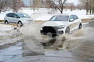 Motion car, big puddle of water spray from the wheels.