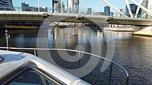 Motion footage from a tourist cruise boat moving under a modern bridge structure