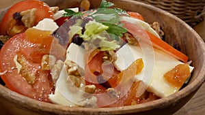 Motion of people eating tomato mozzarella salad with honey on table