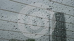 Motion of rainy day view and rain drops sliding down on windshield