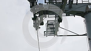 Motion under chairlift tower mechanism against outcast sky
