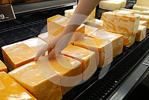 Motion of woman`s hand picking cheese inside superstore