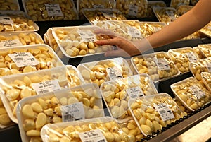 Motion of woman`s hand picking garlic inside superstore