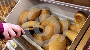 Motion of woman selecting bread on bulk food section inside superstore