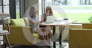 Motivate engaged businesswoman talking to cheerful female colleague