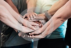 Motivate your team to do their best. a group of friends with their hands stacked in motivation at the gym.